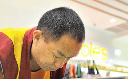 A Tibetan monk crafts a sand mandala. A Tibetan monk crafts a sand mandala.